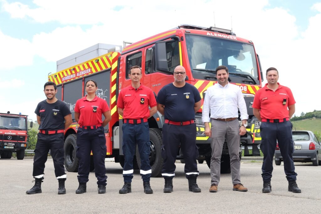 Grupo de bombeiros voluntários de Alenquer e o presidente da Câmara posam em frente a um veículo de combate a incêndios vermelho