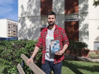 Fábio Galhanas posa no Carregado segurando o livro “Dallas – O Meu Bairro”, junto a um espaço verde da urbanização da Barrada.